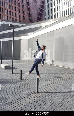 Entrepreneur dancing while listening to music in city Stock Photo