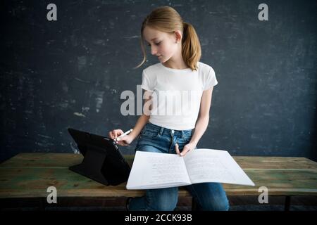 Blond girl learning and using tablet at home Stock Photo