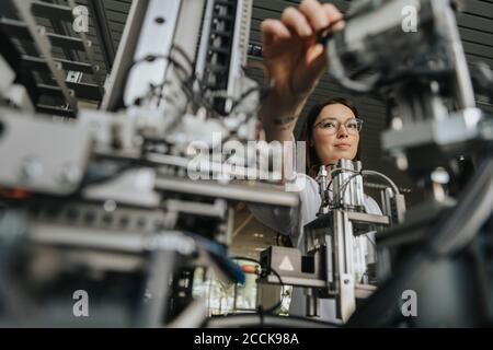 Close-up of young woman examining machinery in laboratory Stock Photo