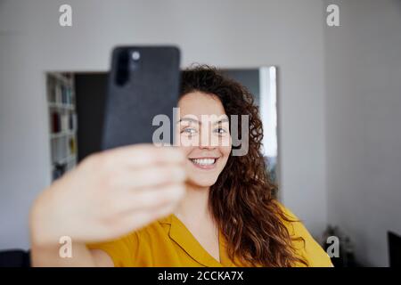 Beautiful happy young woman taking selfie on mobile phone isolated on ...