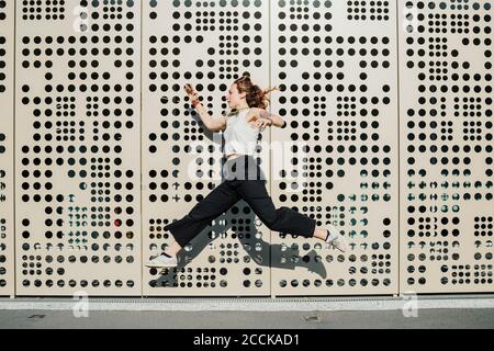 Woman running against wall with holes Stock Photo