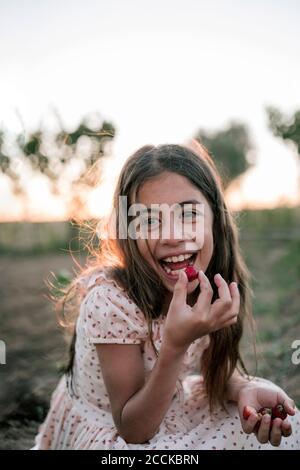 Happy girl eating strawberry in farm Stock Photo