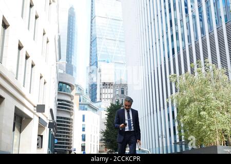 Businessman texting through mobile phone in city Stock Photo