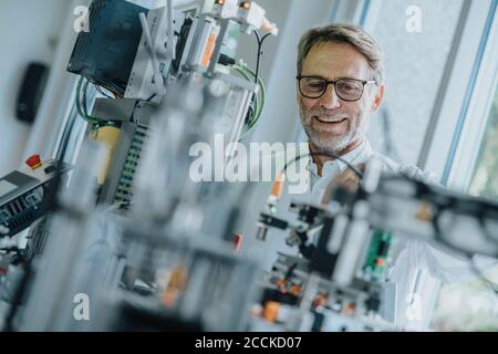 Smiling male engineer examining equipment in laboratory Stock Photo