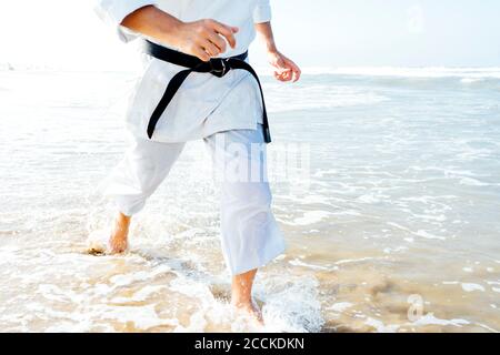 Mature man running in sea during sunny day Stock Photo