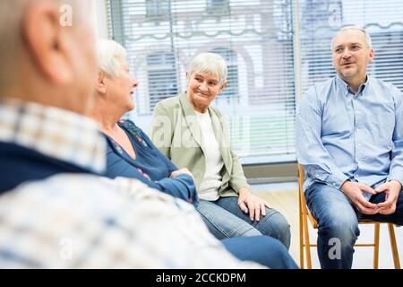 Senior citizens participating in group event in retirement home Stock Photo