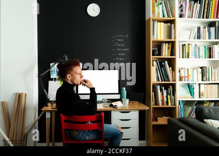 Thoughtful architect looking away while sitting at home office Stock Photo