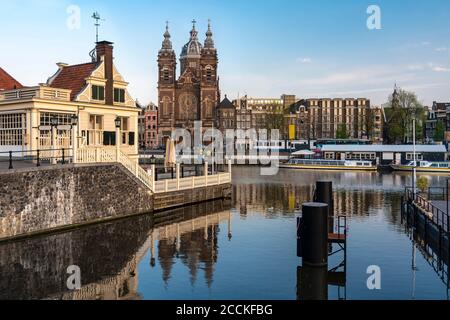 Netherlands, North Holland, Amsterdam, City canal with Basilica of Saint Nicholas in background Stock Photo