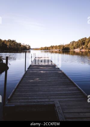 Wooden board walk or jetty in  a lake near a bathing place in s´gothenburg sweden , No people because of COVID Stock Photo