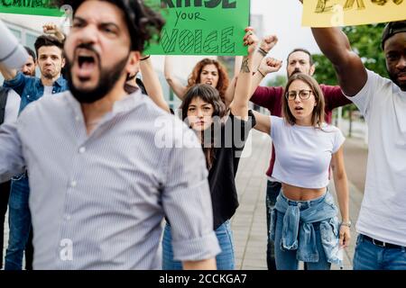 Multi ethnic people with banners protesting on street in city Stock Photo