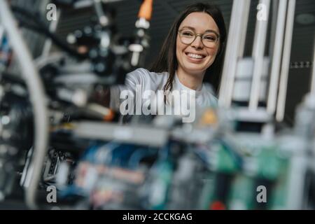 Close-up of smiling female scientist examining machinery in laboratory at factory Stock Photo