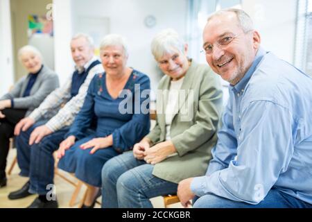 Senior citizens participating in group event in retirement home Stock Photo