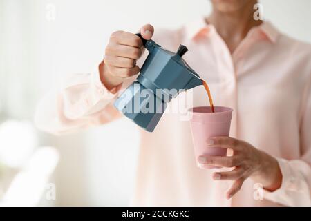 Close-up of woman pouring coffee into cup Stock Photo