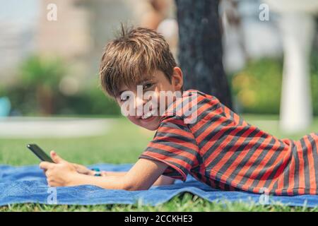 Boy using smart phone while lying in bedroom Stock Photo - Alamy