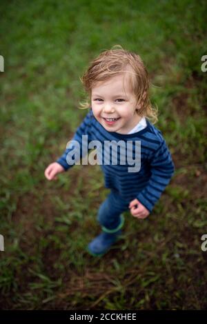 Happy girl with wet hair during rain looking at camera Stock Photo
