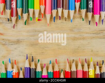 Background with colored pencils and space for copying space on a wooden background, top view. Artistic background Stock Photo