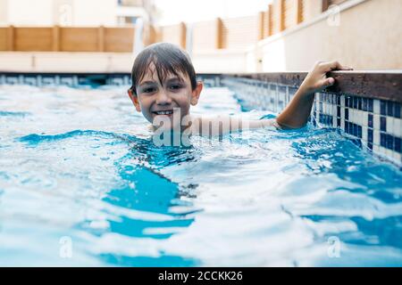 Smiling boy enjoying in swimming pool during summer