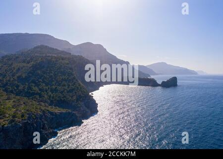Spain, Mallorca, Deia, Drone view of coastal cliffs of Serra de Tramuntana with Sa Foradada peninsula in background Stock Photo