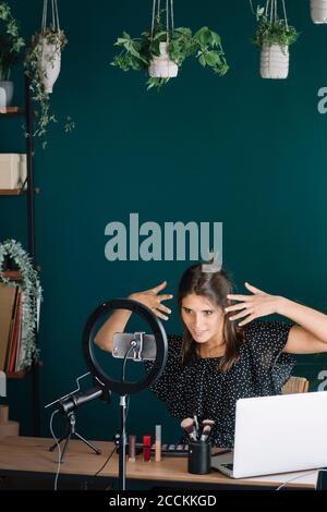 Young woman making a makeup video tutorial Stock Photo