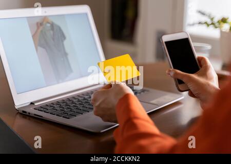 Cropped image of businesswoman with credit card using smart phone while purchasing online at home Stock Photo
