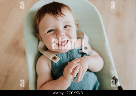 Close-up of cheerful cute baby girl lying in moses basket at home Stock Photo