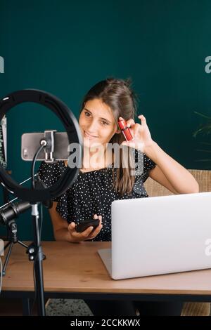 Young woman making a makeup video tutorial Stock Photo