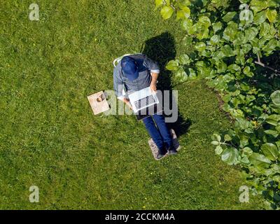 Man using laptop in garden Stock Photo
