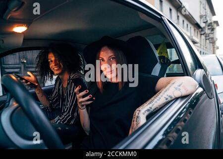 Couple using smart phones while sitting in car seen through window Stock Photo