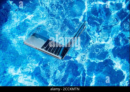 High angle view of laptop floating on swimming pool Stock Photo