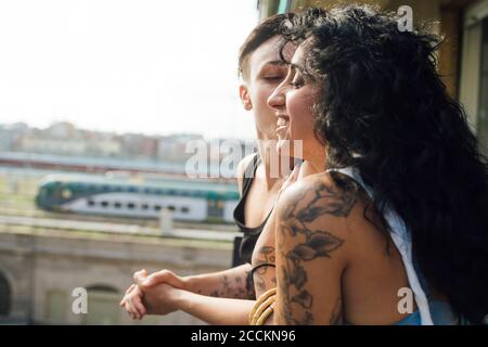 Woman kissing partner in balcony Stock Photo