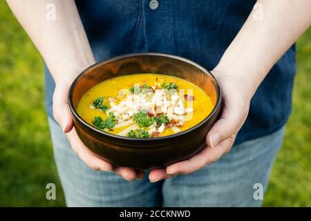 Mans hands holding bowl with dal of lentils, potatoes and vegetables Stock Photo