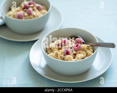 Quinoa porrige on tabletop. Two bowl wit quinoa milk porridge with berries and almond Stock Photo