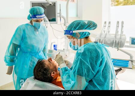 Doctor and nurse with male patient in dentist's clinic Stock Photo
