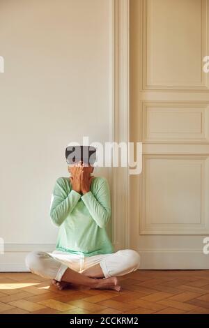 Mature woman using virtual reality simulator while sitting on floor at home Stock Photo