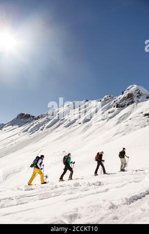 Group of friends ski touring up to a mountain peak, Achenkirch, Austria Stock Photo