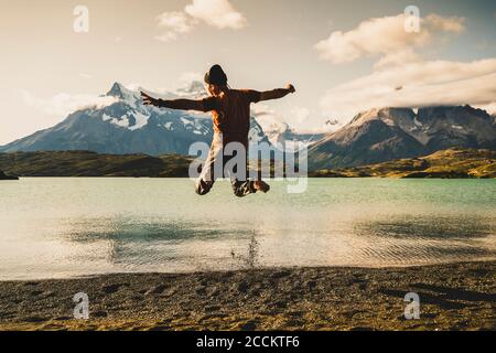 Man jumping and enjoying at lake Pehoe in Torres Del Paine National Park Patagonia, South America Stock Photo