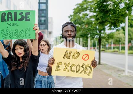 Multi ethnic activists protesting on street in city Stock Photo