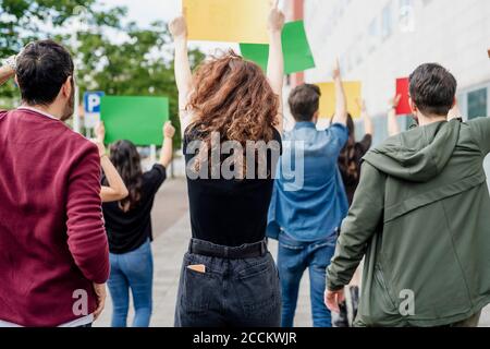 Multi ethnic activists holding banners while protesting on street in city Stock Photo