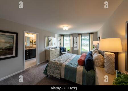 Master bedroom in new modern townhouse with bathroom view. Stock Photo