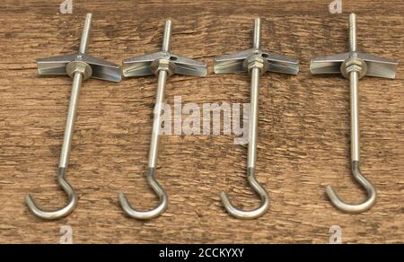 Anchors for drywall ceilings on wooden background Stock Photo