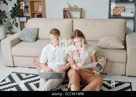 Contemporary young married students preparing for exam in living-room at home Stock Photo