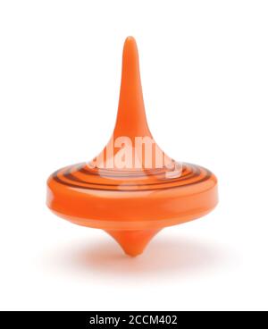 Rotating orange toy spinning top isolated on white. Stock Photo