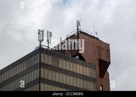 An office building with Mobile phone antennas and masts on the roof Stock Photo