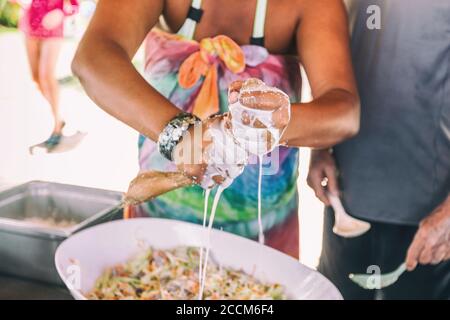 Coconut milk fresh pressed handmade. Woman making homemade recipe pressing natural coconut with hands to demonstrate Polynesian culture, local typical Stock Photo