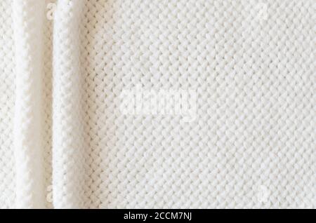 Beige knitted woolen background. Knitwear fabric texture. Stock Photo
