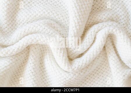 Beige knitted woolen background. Knitwear fabric texture. Stock Photo
