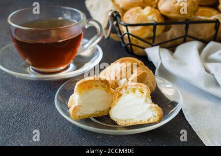 Homemade profitroles pastry filled with custard. Eclairs with cream, french dessert. Stock Photo