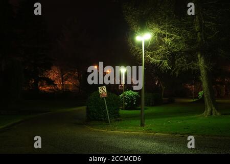 No Safe Pedestrian Access sign under gloomy green glow light street lamp, mercury vapour with dim green off white glow. Scotland, UK, night scene Stock Photo