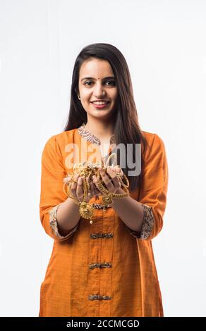 Indian woman holding gold jewelry, ornaments - Asset or Gold Loan concept Stock Photo
