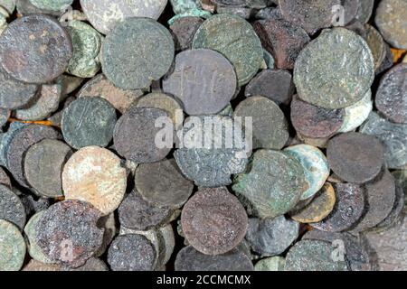 A pile of ancient, worn coins. They are in poor condition and are mostly from ancient Rome. Stock Photo